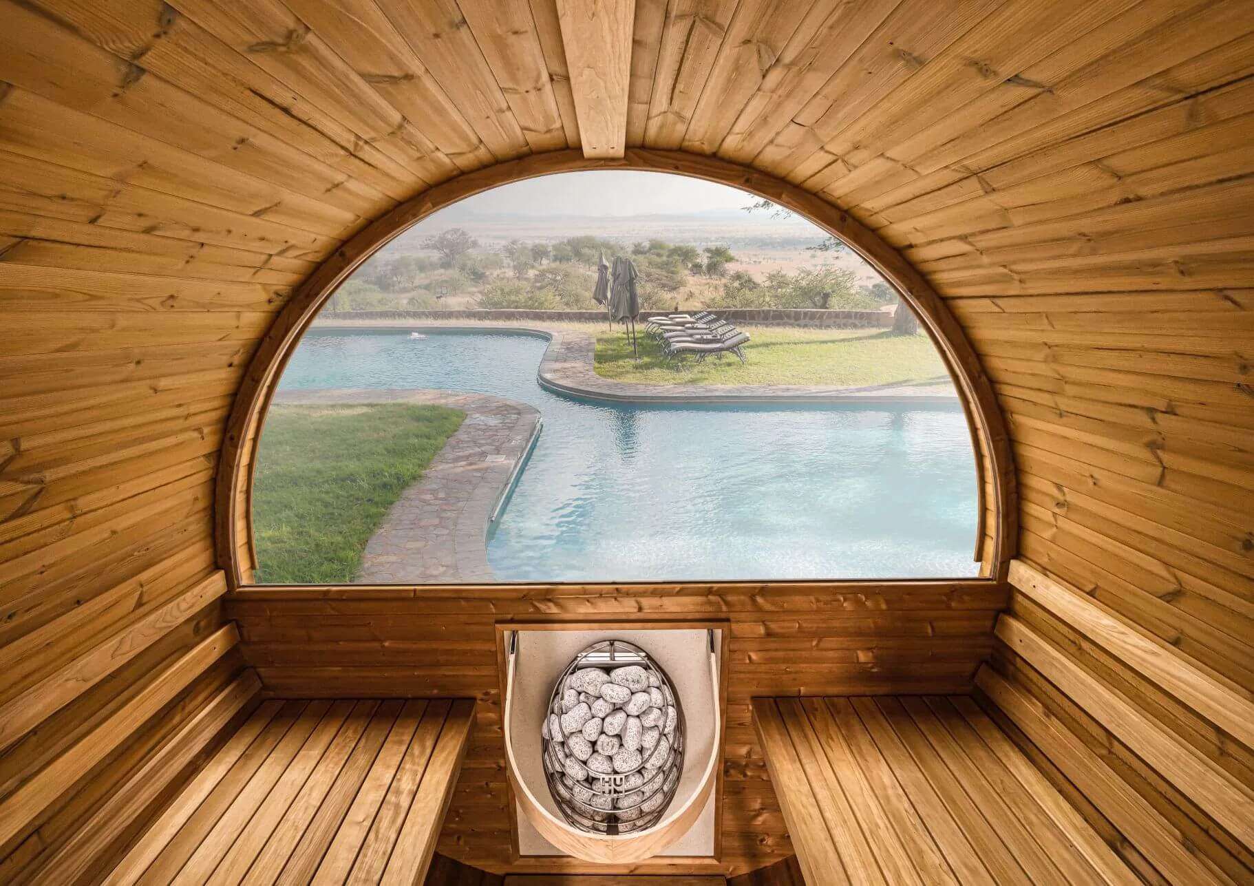View through the panoramic window of a cedar barrel sauna